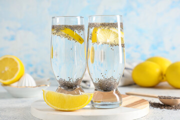 Glasses of lemon water with chia seeds on grunge table, closeup