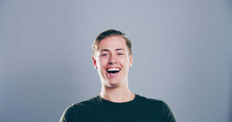Portrait, man and happy in studio for funny joke, crazy comedy and smile isolated on gray...