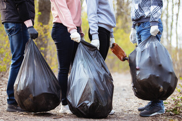 A volunteer collects trash left by tourists in nature