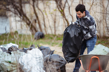 A volunteer collects trash left by tourists in nature
