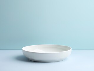 Minimalist white ceramic bowl on light blue background.