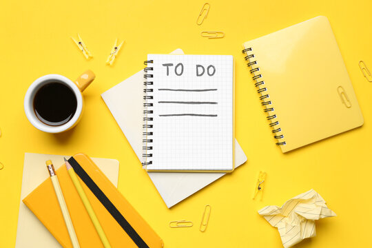Empty to-do list with notebooks, cup of coffee and stationery on yellow background