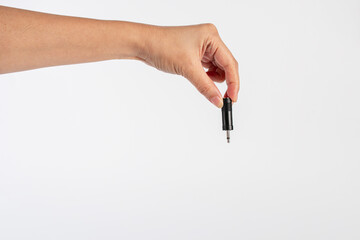 Hand and black audio cable aux isolated on white background