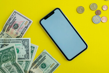 Mockup, smartphone, dollars and euro coins on a yellow background.