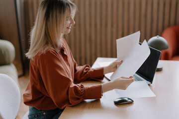 Woman using blank papers to analyze and document business activity