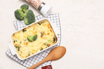 Baking dish with tasty pasta, broccoli and sea salt on light background