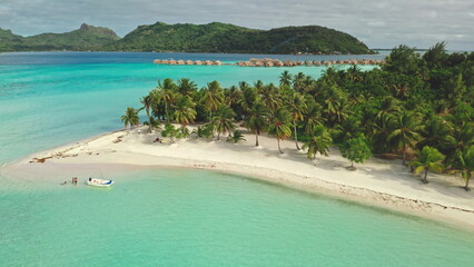 Multiple aerial views show a tropical island resort in Bora Bora with overwater bungalows, palm trees, white sand beaches, and stunning turquoise waters © Goinyk