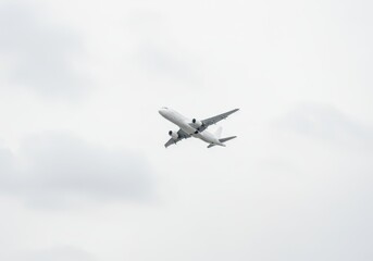 Airplane flying highly in the cloudy sky for travel industry. Commercial aviation and a great symbol of modern technology innovation to aircraft flying.