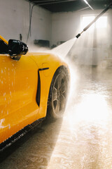 Procedure of high pressure water washing from water gun to the sports car. Detailing process of...