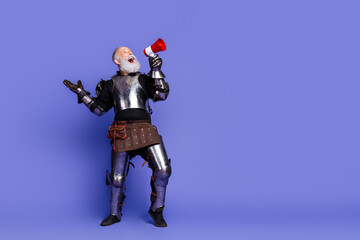 Elderly man in shining knight's armor with a megaphone on a purple background