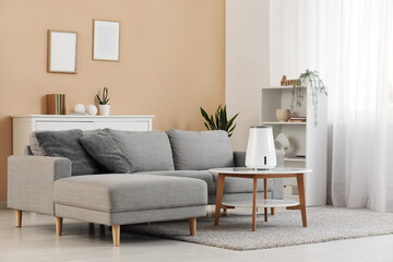 Interior of living room with sofa and air humidifier on table