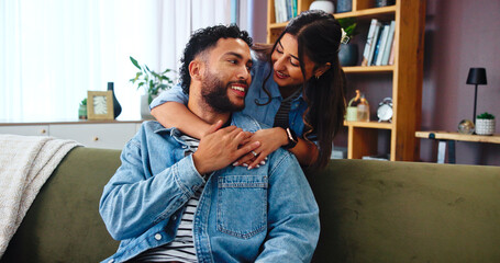 Obraz premium Home, relax and couple on sofa, hug and bonding together with happiness in lounge. Embrace, apartment and man with woman, calm and smile with romance, relationship and love with marriage and talking