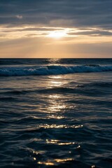 Obraz premium arafed view of a sunset over the ocean with waves