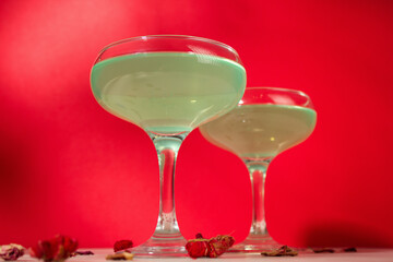 Green cocktail on red background. glass of alcoholic cocktail