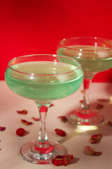 Green cocktail on red background. glass of alcoholic cocktail