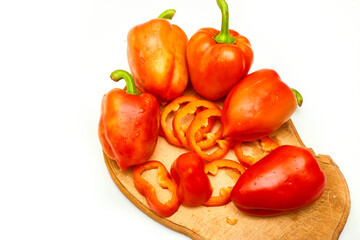 Red sweet ripe pepper cut into circles,slices on cooking desk