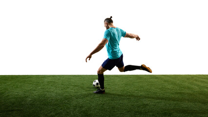 Dynamic back view photo of young football athlete, dressed blue uniform, training kicks ball in motion on green stadium against white background. Concept of professional sport, championship, match.