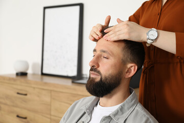 Psychologist working with patient during hypnosis session indoors, closeup. Space for text