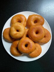 Delicious looking golden brown donuts arranged on a white plate