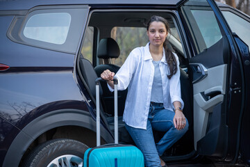 Young girl traveler waiting outside the car with backpack.