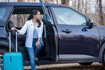 Young girl traveler waiting outside the car with backpack.