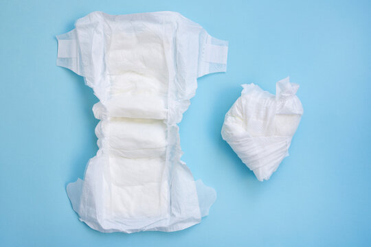 New and used baby diapers on a blue background..