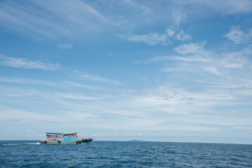 Lonely Boat Floating in Bright Tropical Ocean