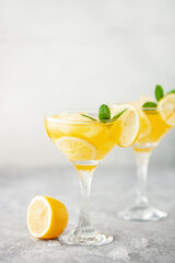 Summer limoncello margarita cocktail with lemons and mint in a glass