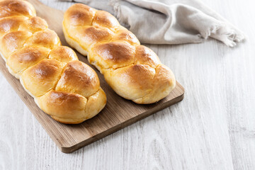 Traditional Easter braided bread. Tsoureki braid on white wooden table. Copy space