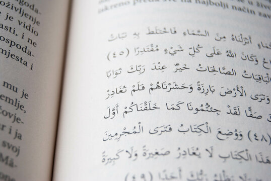 Close-up photo of Arabic text on aged book pages, showcasing intricate calligraphy and historical depth.
