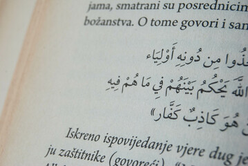 Close-up photo of Arabic text on aged book pages, showcasing intricate calligraphy and historical...