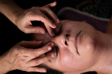 facial massage, professional's fingers in patient's eyes