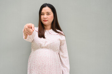 young pregnant woman pointing finger to viewer