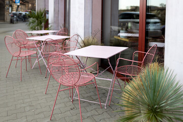 Modern outdoor terrace with seating arrangement. Fashionable outdoor restaurant tables, summer time. Tables and chairs at sidewalk cafe. Touristic setting, cafe table, sidewalk cafe furniture