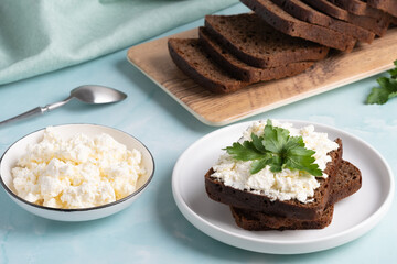 Delicious rye bread with cottage cheese and parsley on a cozy kitchen table