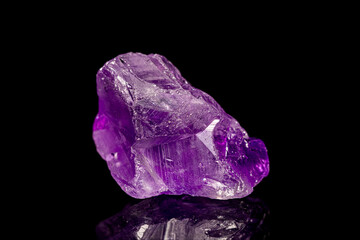 Natural rough amethyst gemstone on dark background (selective focus)
