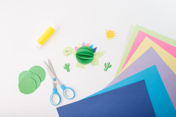 craft supplies on white background. Flat lay composition with scissors, glue stick, colored paper,...