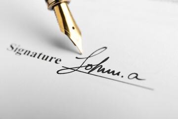 Fountain pen leaving signature on contract, closeup