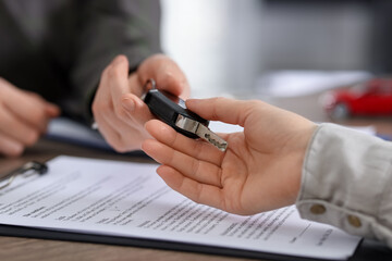 Buying auto. Client getting car key at table, closeup