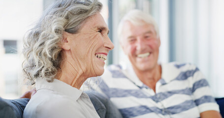Laughing, senior couple and happy in home, talking and romance for relationship in living room. House, old man and woman in retirement, comfortable and elderly people in lounge, funny or marriage