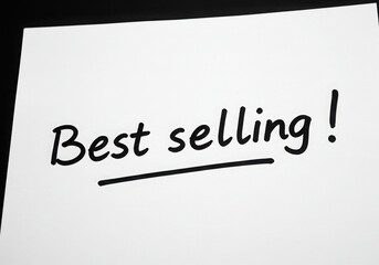 Fototapeta premium A white paper with the words best selling written in black ink with an exclamation point at the end