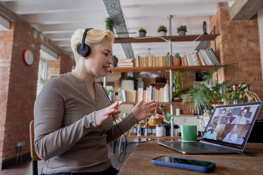 Woman in Headphones Engaging in Video Conference