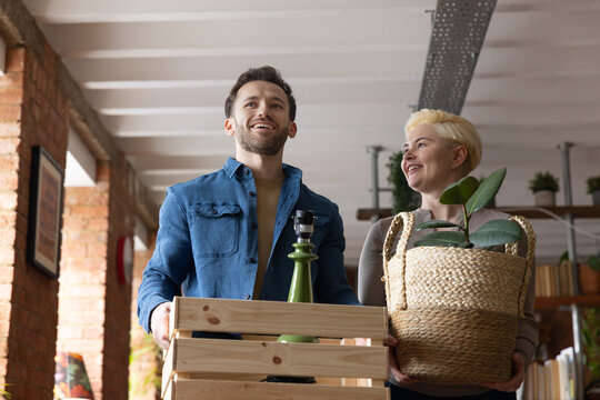 Couple carrying boxes moving into their first home together