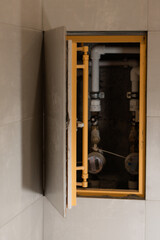 Hidden revision sanitary hatch on the wall of bathroom.