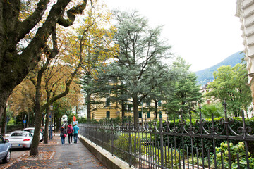 Obraz premium Travelers people walking at footpath beside road in small alley go to Merano Christmas Market in Tyrol, Italy