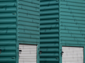 Fototapeta premium metal container on end or upright painted turquoise with white metal garage door and exterior light creative ways to use containers horizontal image room for type Base 31 Prince Edward County Ontario