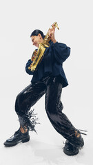 Woman in black outfit passionately performing, playing saxophone, bending into rhythm with...