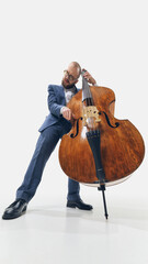 Low angle view of man in formal wear, professional musician in suit passionately playing double...