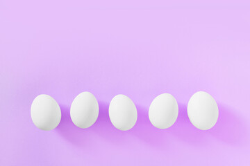 Frame of Easter white natural eggs set isolated on pastel pink background. Stylish trendy composition with chicken egg. Flat lay, top view, place for text. Happy eco-friendly holiday, minimal concept