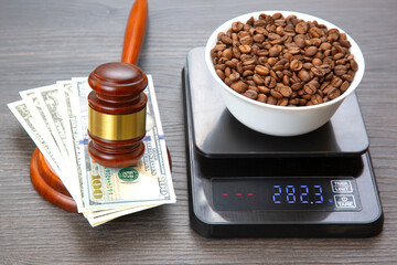 A detailed shot of a digital scale with a bowl of coffee beans, paired with a gavel and stacks of...